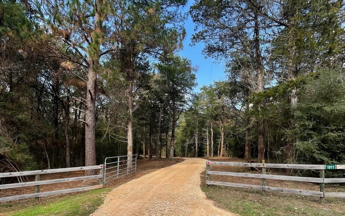 New gravel driveway entrance with fence and gate built by Prestige Land Services near Sealy, Texas